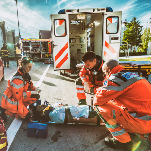 Emergency responders providing care beside an ambulance