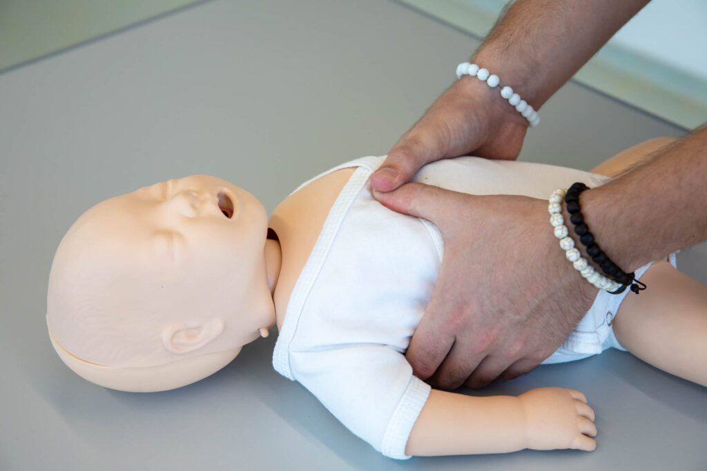 Instructor practicing infant CPR on a training manikin