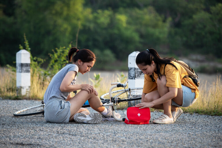 People practicing first aid outdoors with a first aid kit