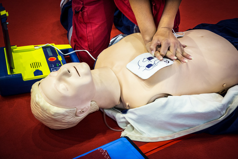CPR class practicing chest compressions with an AED trainer